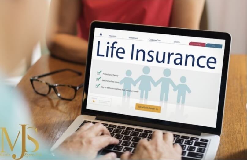 Two people sitting at a table looking at their life insurance policy on a laptop